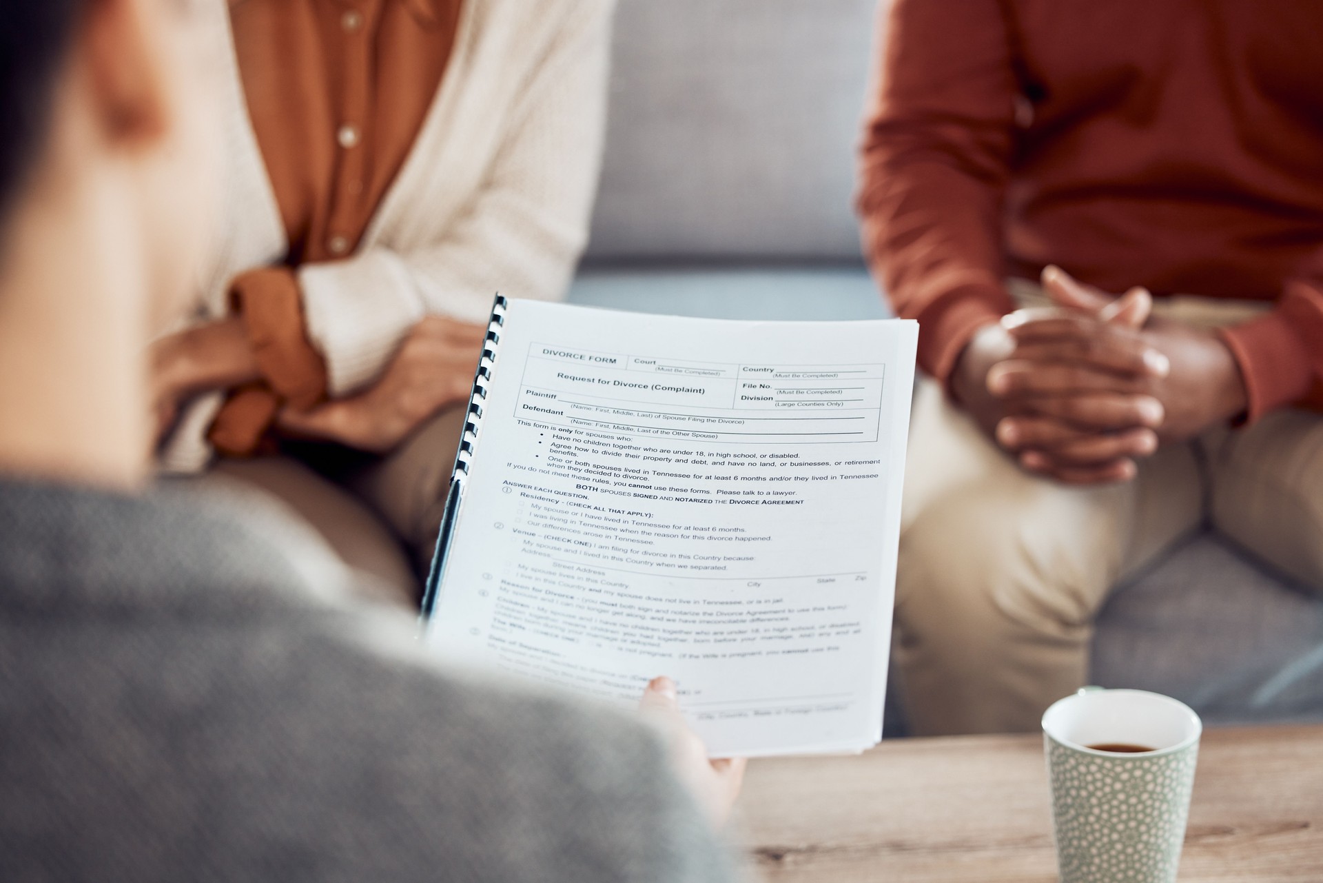 Couple, divorce form and family lawyer for therapy and documents apply for legal advice together. Meeting, marriage compliance worker and conversation with application contract on sofa in office